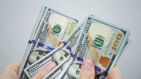 Person considering multiple US dollar 100 banknotes Stock Footage 287034276