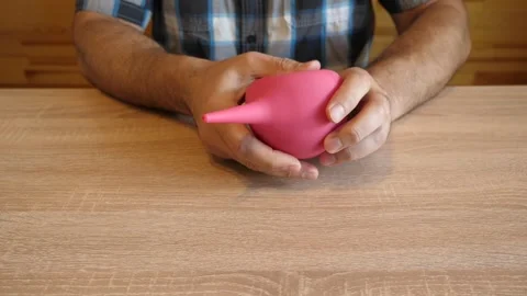 A person continuously squeezes a rubber bulb, releasing air through a narrow  Stock Footage 341260176