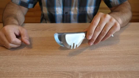A person continuously taps metal kitchen tongs, creating rhythmic metallic st Stock Footage 341260208
