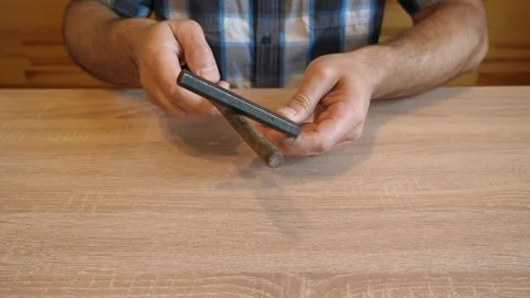 A person continuously taps two metal tools together, creating rhythmic metall Stock Footage 341263620