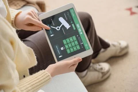 Person controlling smart home security system on tablet Stock Photos