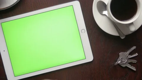 Person controlling a tablet with large green screen for replacement at a cafe Stock Footage 75457596