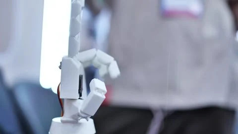 A person controls an artificial robotic arm via wires on their hand. Stockbeeldmateriaal 321348410