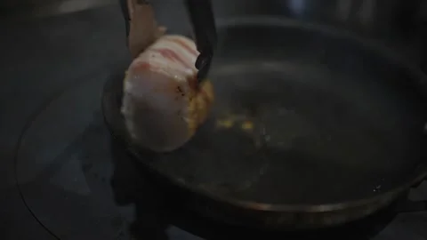 A person is cooking bacon in a pan Stock Footage 306577068