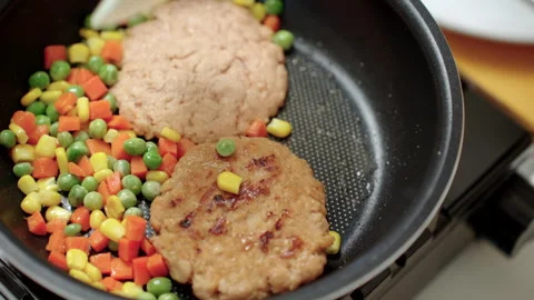 Person cooking a plant-based burger in a modern kitchen. Meat alternative. Stock Footage 338331201