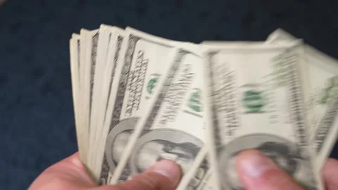 Person counting a large wad of one hundred dollar bills Stock Footage 347972124