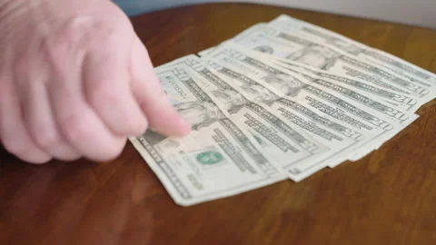 Person counting money onto a table Stock Footage 149800295