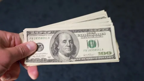 Person counting a stack of one hundred dollar bills Stock Footage 347972137