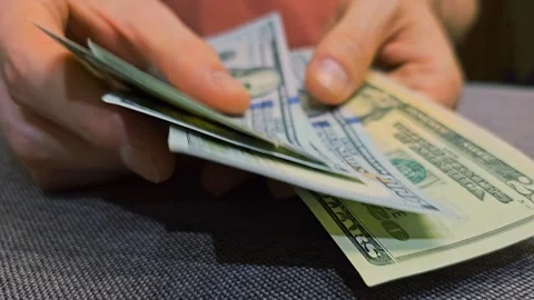 Person counting stack of US hundred dollar bills. Money Transfer Stock Footage 310851548
