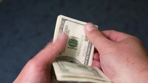 Person counting stack of US one hundred dollar bills Stock Footage 347972152