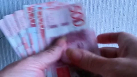 The person is counting the Swedish five-hundred-kronor bills in the room. Long Video stock 320988506