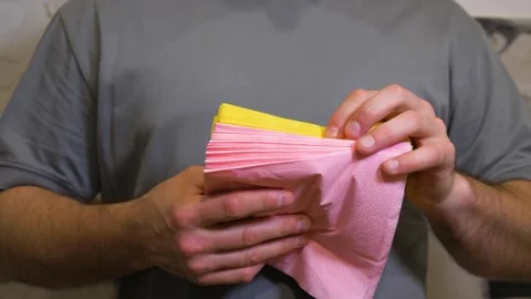 A person is counting table napkins while holding the stack in their hands Stock Footage 340209149