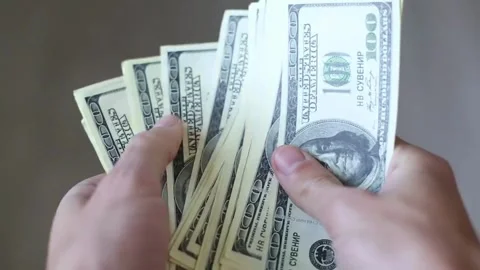 Person counts dollar banknotes in hands. Man counting American money by his Stock-Footage 336259865