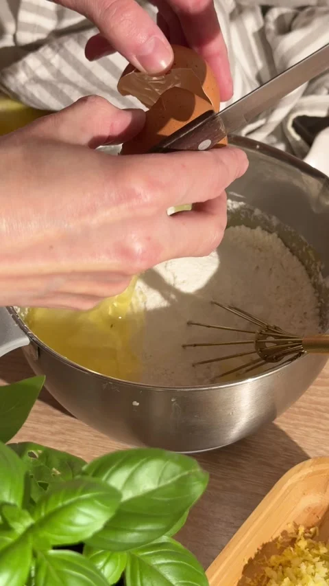 Person cracking an egg into bowl with flour for baking Stock Footage 337194901