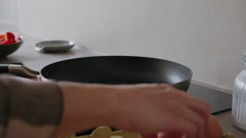 Person Cracking Eggs into a Frying Pan Stock Footage 345834742