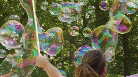 Person Creating Giant Soap Bubbles in City Park Stock Footage 314885021