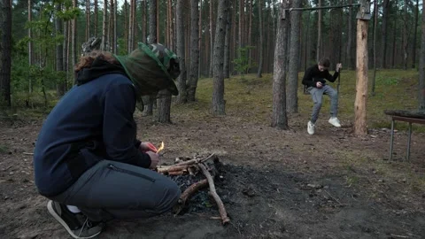 Person crouched lighting campfire Stock Footage 339504889