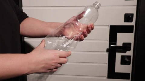 Person crushing an empty plastic water bottle with their hands Stock Footage 339176452