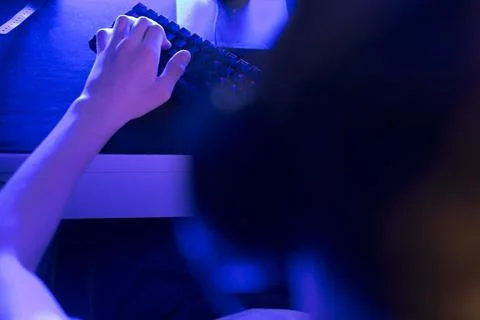 A person is currently using a computer mouse and keyboard in a dark room 库存照片