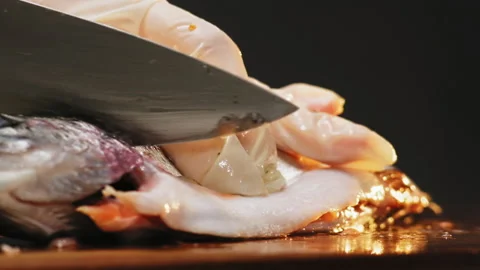Person cuts head of red fish with sharp knife on board 库存影片 149804522