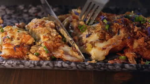 A person cuts a portion of potato pancakes. Stock Footage 311260053