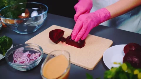 Person cutting fresh beetroot on cutting board in kitchen 库存影片 342824240