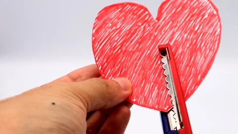 A person cutting a heart with scissors 動画素材 335648006