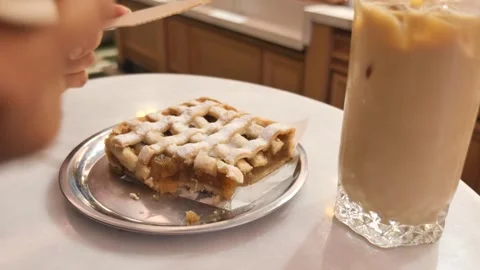 Person cutting lattice apple pie on metal plate with wooden cutlery next to.. Stock Footage 332886355