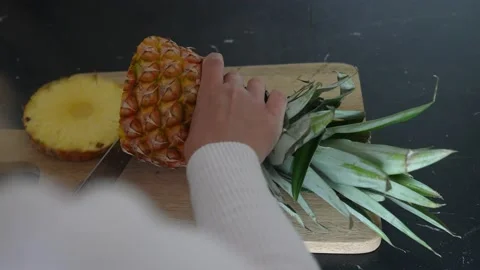 Person cutting pineapple on kitchen counter at home 動画素材 237273880