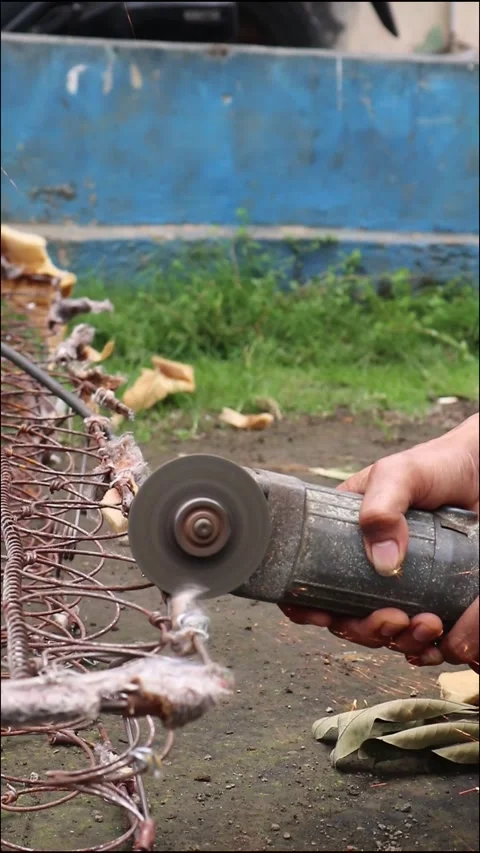 Person cutting rusty metal with an angle grinder, creating bright sparks. Stock Footage 303200453