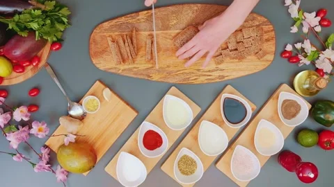 Person cutting rye bread into croutons on wooden cutting board indoors 스톡 동영상 342858659