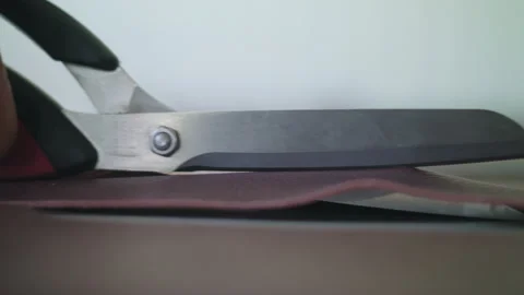Person cutting scissors through leather on counter Stock Footage 275078735