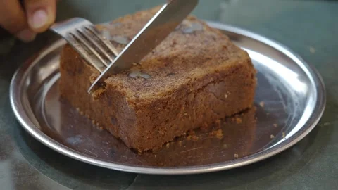 Person Cutting a Slice of Walnut Loaf Cake on a Plate Stock Footage 336830911