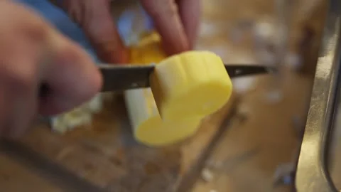 A person is cutting a yellow object with a knife Stock Footage 295367435