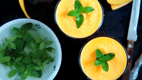 Person decorates orange smoothie 스톡 동영상 79932497
