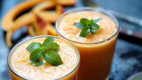 Person decorates orange smoothie Video stock 79932855