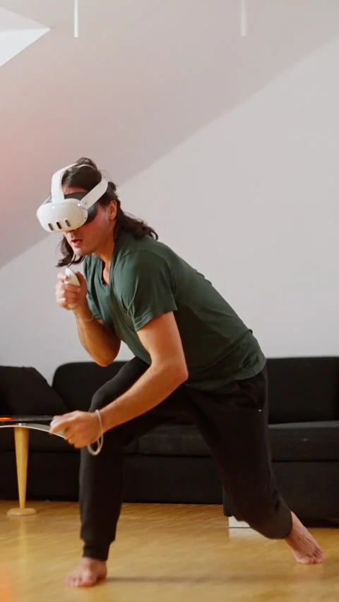 Person is deeply engaged in gaming with a VR headset in a living room. Man Stock Footage 294615765