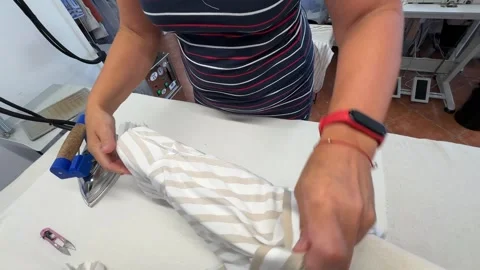 A person demonstrate how to iron a striped shirt showcasing effective techniques Video stock 312565686
