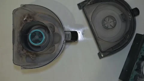 A person demonstrates the cleaning process of a dust container. In the first Stock Footage 339005189