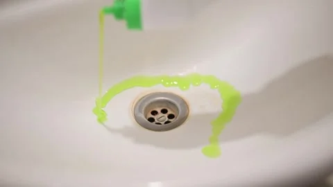A person demonstrates how to clean a sink by pouring liquid cleaner into the 스톡 동영상 337643352