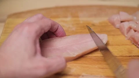 A person demonstrates the skill of cutting fish into smaller pieces using a Stock-Footage 338298312