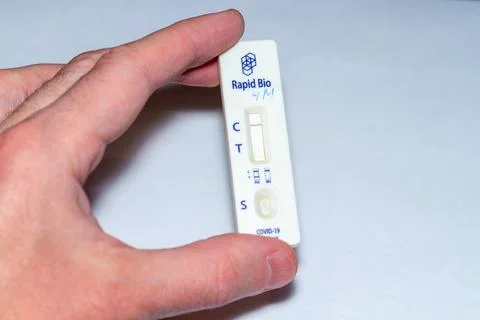 A person is demonstrating a quick diagnostic device utilized for identifying Stock Photos