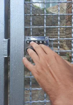 A person dials a code on a digital lock. Breaking the combination lock. Metal Stock Photos
