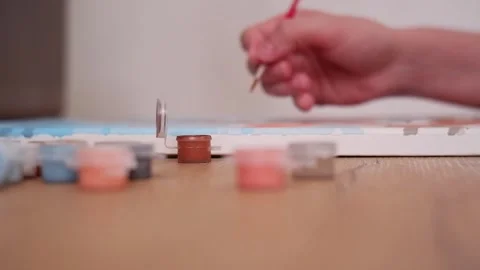 Person dipping paintbrush and drawing on canvas Stock Footage 340131153