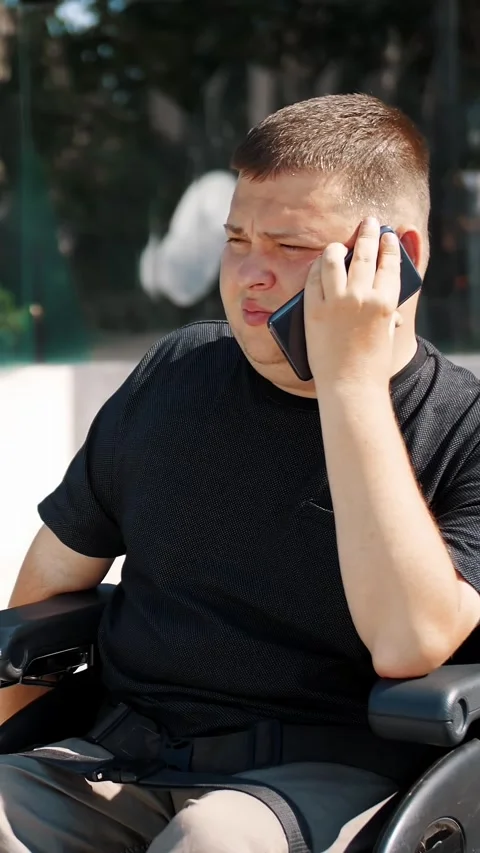 Person with a disability. young man is talking on the phone, outdoors, in the Stock Footage 318807515