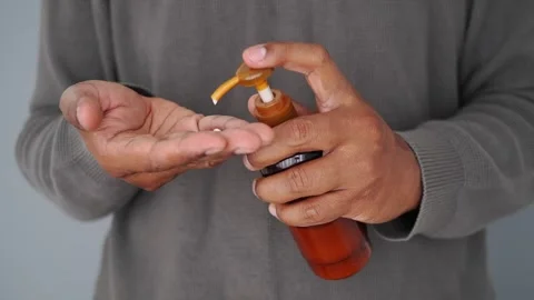 Person Dispensing Moisturizing Lotion into Hand Stock Footage 345696771