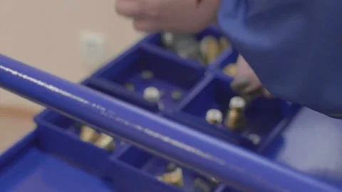 The person distributes the components of the disassembled part to containers Stock Footage 147254992