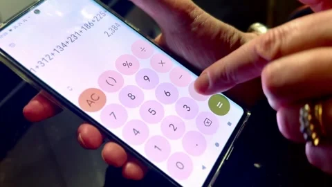 Person doing math addition adding up numbers on calculator app on smart phone Stock Footage 327936034