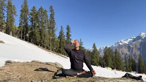 Person doing pranayama exercise seated on mat in winter landscape outdoors Stock Footage 333700861