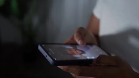 Person doomscrolling on a smart device at night time 動画素材 344756574